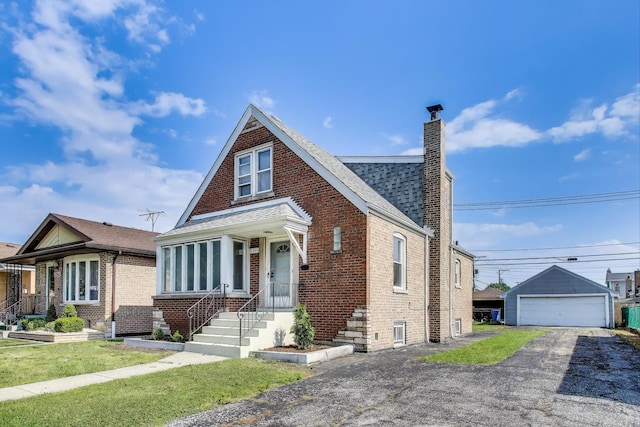 5949 W 55th St, Chicago, IL 60638 - view of front of property featuring brick siding, a chimney, a detached garage, an outbuilding, and a shingled roof