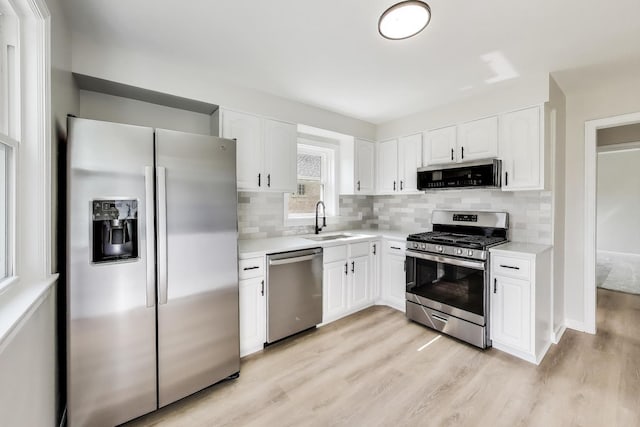 5949 W 55th St, Chicago, IL 60638 - kitchen featuring stainless steel appliances, light wood finished floors, light countertops, decorative backsplash, and white cabinetry