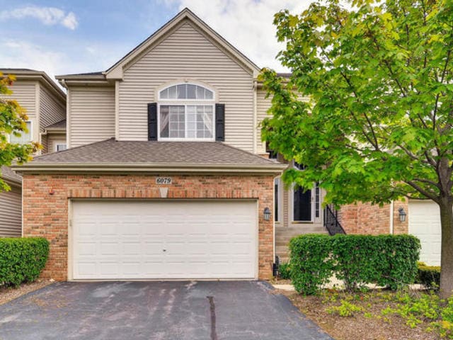 6079 Delaney Dr, Hoffman Estates, IL 60192 - traditional home featuring brick siding, asphalt driveway, and a garage
