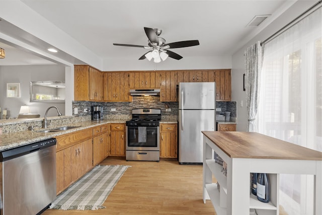 17456 Sauk Dr, Lockport, IL 60441 - kitchen featuring appliances with stainless steel finishes, under cabinet range hood, a ceiling fan, tasteful backsplash, and brown cabinets