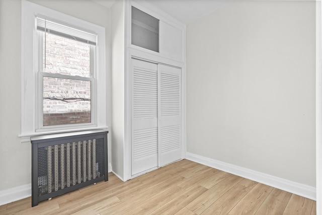 1332 Euclid Ave, Berwyn, IL 60402 - unfurnished bedroom featuring radiator, light wood-style flooring, and a closet