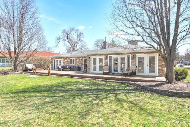 1425 N River Rd, Mchenry, IL 60051 - rear view of house featuring french doors, a deck, stone siding, a chimney, and a lawn
