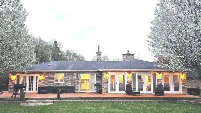 1425 N River Rd, Mchenry, IL 60051 - back of house featuring french doors, a deck, stone siding, and a chimney