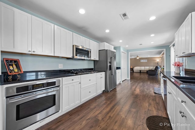 1425 N River Rd, Mchenry, IL 60051 - kitchen with appliances with stainless steel finishes, dark countertops, white cabinetry, dark wood-type flooring, and recessed lighting