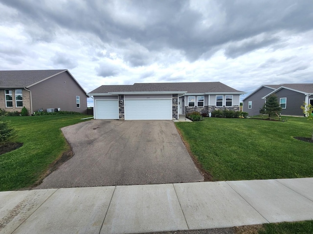 12549 New York St, Loves Park, IL 61111 - ranch-style house with stone siding, asphalt driveway, a front lawn, and a garage