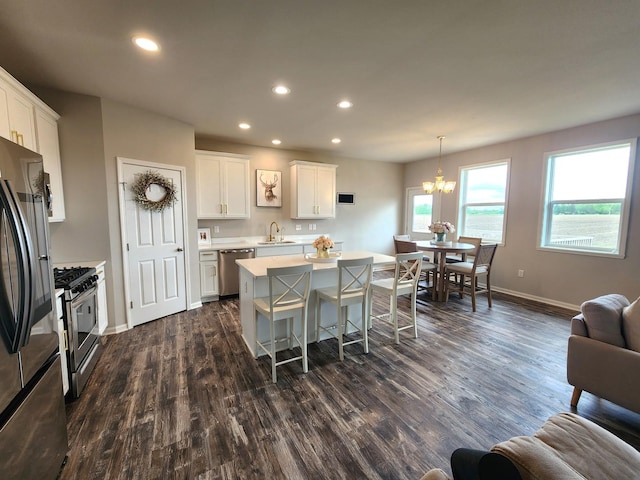 12549 New York St, Loves Park, IL 61111 - kitchen featuring stainless steel appliances, light countertops, dark wood finished floors, recessed lighting, and a kitchen breakfast bar