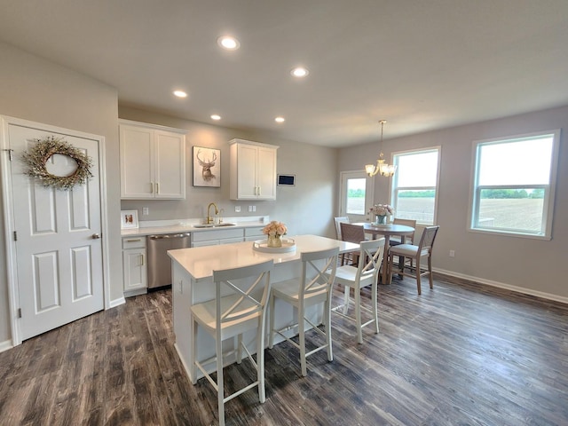 12549 New York St, Loves Park, IL 61111 - kitchen with stainless steel dishwasher, light countertops, dark wood-style floors, a chandelier, and white cabinets