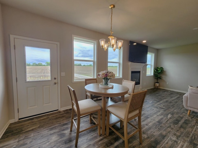 12549 New York St, Loves Park, IL 61111 - dining area with a chandelier, dark wood-style floors, and a glass covered fireplace