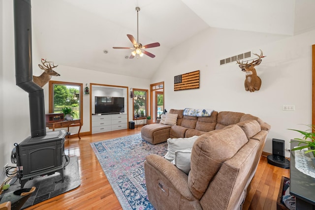 990 Fox Trail Ln, Somonauk, IL 60552 - living room featuring a ceiling fan, a wood stove, light wood-style floors, and high vaulted ceiling