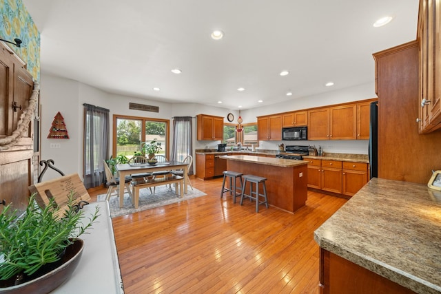 990 Fox Trail Ln, Somonauk, IL 60552 - kitchen with black appliances, brown cabinetry, a center island, recessed lighting, and a breakfast bar area