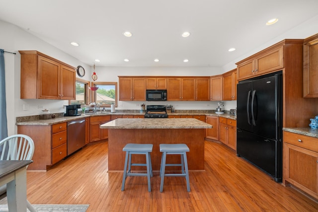 990 Fox Trail Ln, Somonauk, IL 60552 - kitchen with black appliances, brown cabinetry, a center island, light wood-style floors, and recessed lighting
