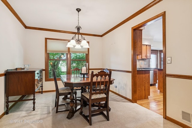 321 Breckenridge Dr, Aurora, IL 60504 - dining area featuring a chandelier, plenty of natural light, light carpet, and ornamental molding
