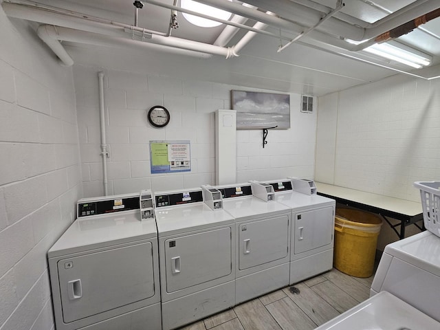 520 Burning Tree Ln Unit 111, Naperville, IL 60563 - community laundry featuring wood finished floors, concrete block wall, and washing machine and clothes dryer