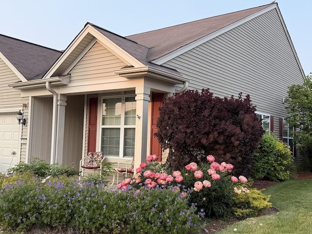 13044 Redstone Dr, Huntley, IL 60142 - view of side of property featuring an attached garage, a shingled roof, and a porch