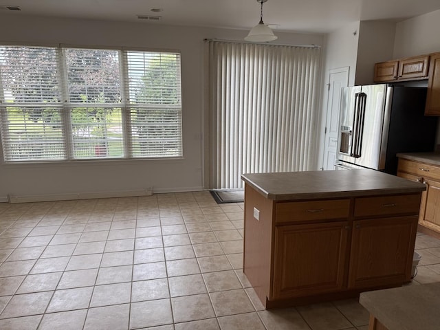 13044 Redstone Dr, Huntley, IL 60142 - kitchen featuring stainless steel fridge with ice dispenser, light tile patterned floors, a kitchen island, pendant lighting, and dark countertops