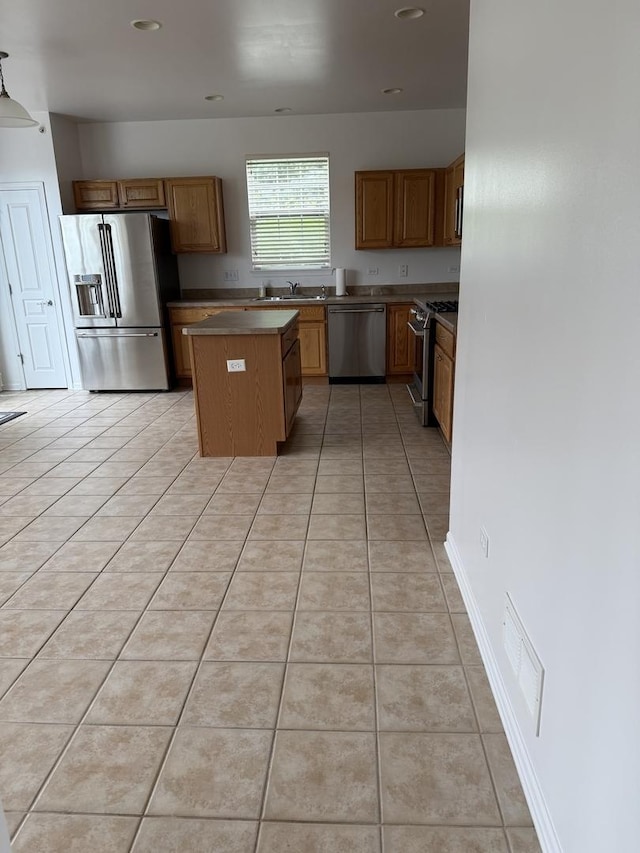 13044 Redstone Dr, Huntley, IL 60142 - kitchen featuring stainless steel appliances, a center island, light tile patterned floors, brown cabinetry, and recessed lighting