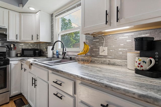 405 N Vorcey St, Tolono, IL 61880 - kitchen featuring stainless steel range with electric stovetop, black microwave, white cabinetry, backsplash, and recessed lighting