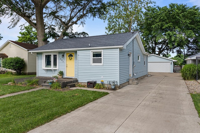 405 N Vorcey St, Tolono, IL 61880 - bungalow-style home featuring a garage, an outbuilding, a front yard, and roof with shingles