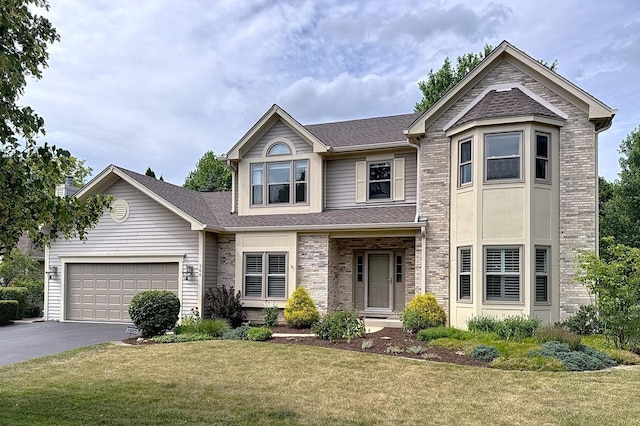 566 Primrose Ln, Crystal Lake, IL 60014 - view of front facade featuring asphalt driveway, brick siding, an attached garage, and a front lawn