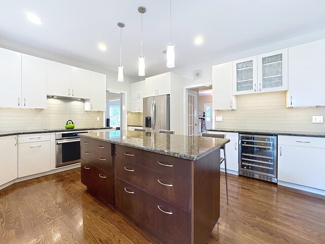 566 Primrose Ln, Crystal Lake, IL 60014 - kitchen with wine cooler, appliances with stainless steel finishes, dark wood-style flooring, a kitchen island, and recessed lighting