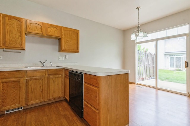 3856 Pathfinder Ln, Joliet, IL 60435 - kitchen with black dishwasher, a peninsula, dark wood finished floors, light countertops, and pendant lighting