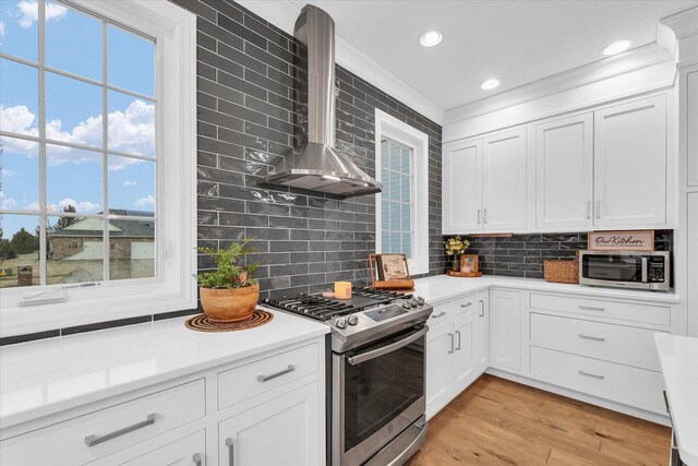 1603 English Oak Dr, Champaign, IL 61822 - kitchen with stainless steel appliances, wall chimney exhaust hood, decorative backsplash, white cabinets, and crown molding