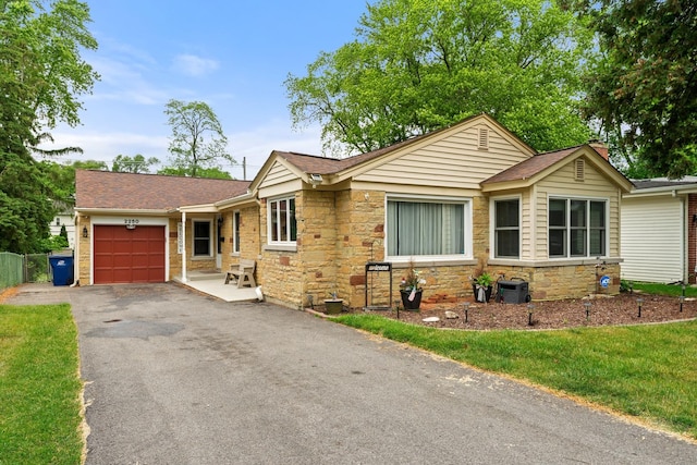2250 Corona Rd, Waukegan, IL 60087 - ranch-style house with a garage, driveway, stone siding, and roof with shingles
