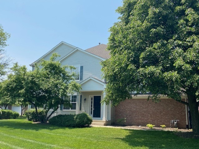 1830 Maureen Dr, Hoffman Estates, IL 60192 - view of property hidden behind natural elements featuring a front lawn and brick siding