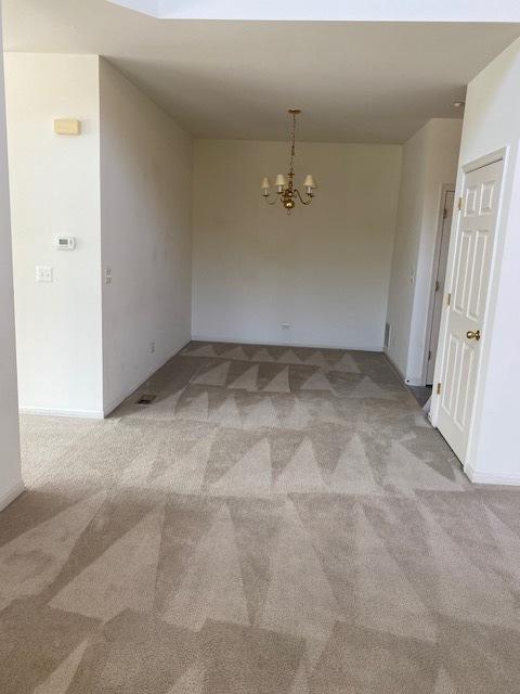 1830 Maureen Dr, Hoffman Estates, IL 60192 - unfurnished room with light colored carpet and a chandelier