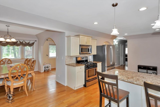352 Rye Rd, Mundelein, IL 60060 - kitchen with stainless steel appliances, arched walkways, light wood-style floors, tasteful backsplash, and recessed lighting