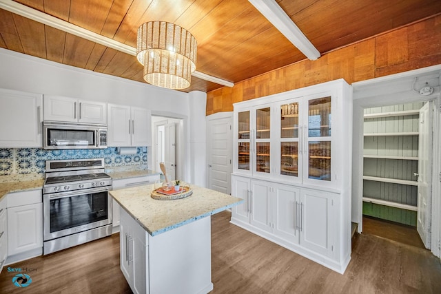1659 N Francisco Ave, Chicago, IL 60647 - kitchen featuring appliances with stainless steel finishes, a wooden ceiling with exposed beams, white cabinets, a chandelier, and wood finished floors