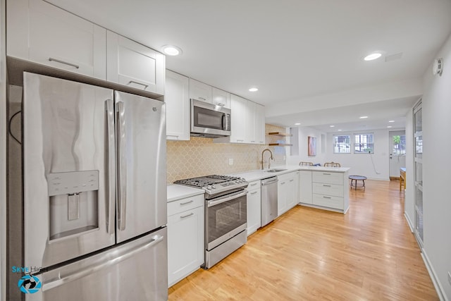 1659 N Francisco Ave, Chicago, IL 60647 - kitchen featuring appliances with stainless steel finishes, a peninsula, white cabinetry, decorative backsplash, and light countertops