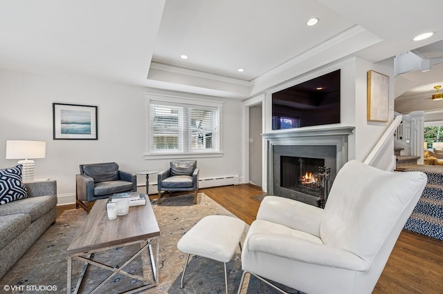 938 Edgemere Ct, Evanston, IL 60202 - living room featuring baseboard heating, a warm lit fireplace, a raised ceiling, wood finished floors, and recessed lighting