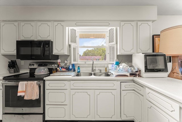 1356 Briarcliff Dr, Rantoul, IL 61866 - kitchen featuring black microwave, stainless steel electric range oven, white cabinets, and light countertops
