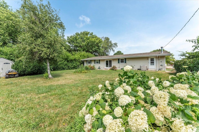 1356 Briarcliff Dr, Rantoul, IL 61866 - rear view of property featuring a lawn and a storage shed