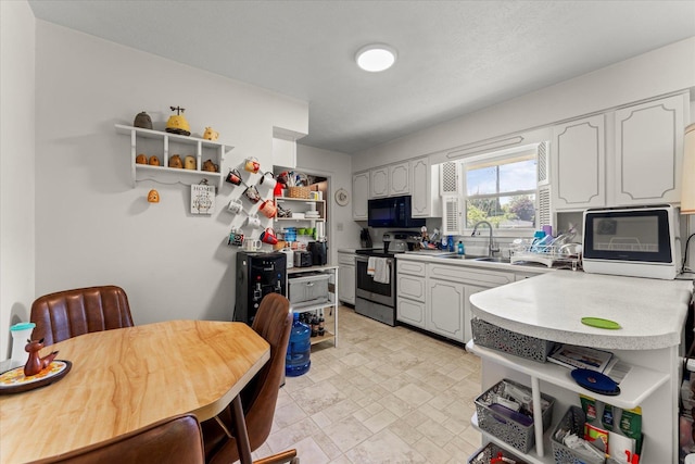 1356 Briarcliff Dr, Rantoul, IL 61866 - kitchen with stainless steel range with electric cooktop, open shelves, black microwave, light countertops, and white cabinetry