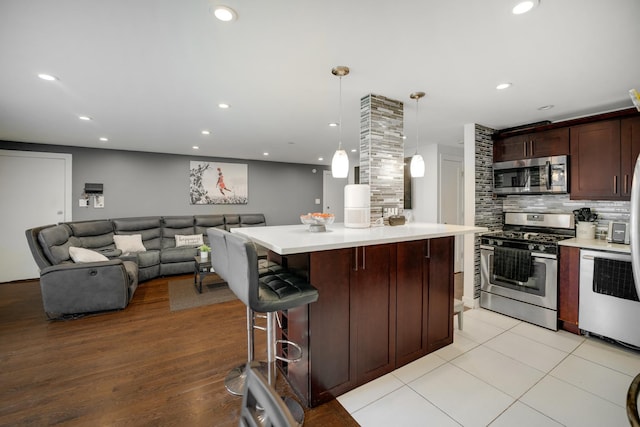 9819 Nottingham Ave Unit 106, Chicago Ridge, IL 60415 - kitchen featuring appliances with stainless steel finishes, light countertops, tasteful backsplash, open floor plan, and decorative light fixtures