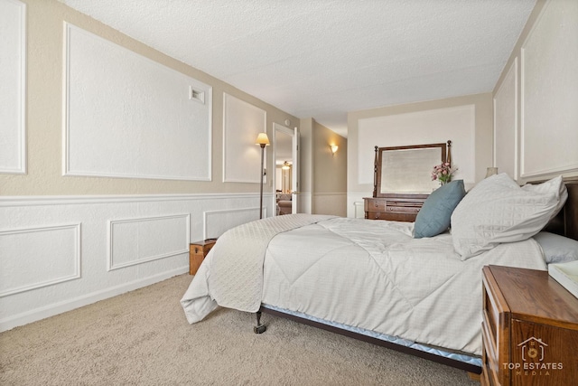 1 Renaissance Pl Unit 1121, Palatine, IL 60067 - bedroom with a textured ceiling, carpet, a decorative wall, and a wainscoted wall