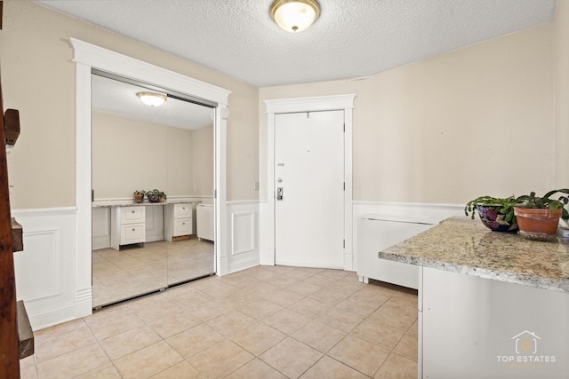 1 Renaissance Pl Unit 1121, Palatine, IL 60067 - foyer featuring a textured ceiling, wainscoting, light tile patterned flooring, and a decorative wall