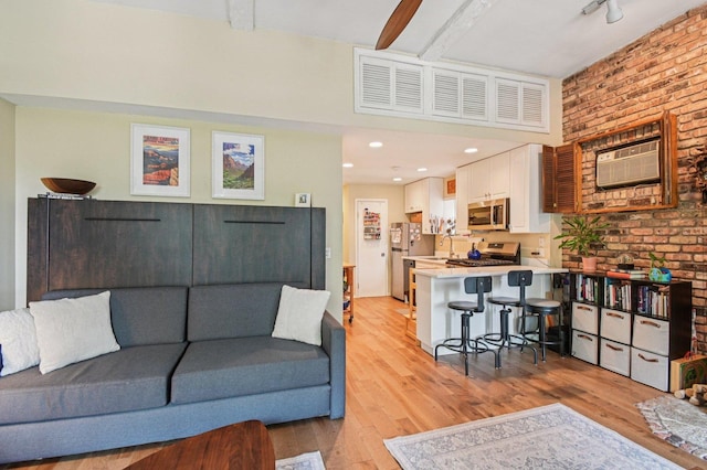 1873 N Fremont St Unit 3Fw, Chicago, IL 60614 - living area with light wood-style floors, a wall unit AC, and brick wall