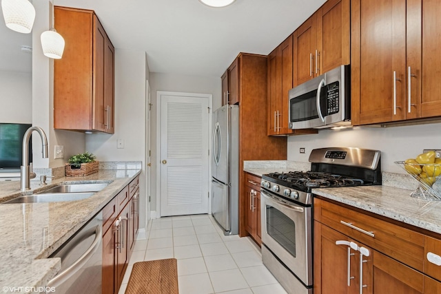926 Bromley Pl, Northbrook, IL 60062 - kitchen featuring stainless steel appliances, brown cabinetry, light tile patterned floors, and light stone countertops