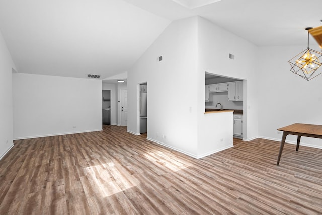 1401 Clove Ct Unit D, Mount Prospect, IL 60056 - unfurnished living room with wood finished floors, a chandelier, and high vaulted ceiling