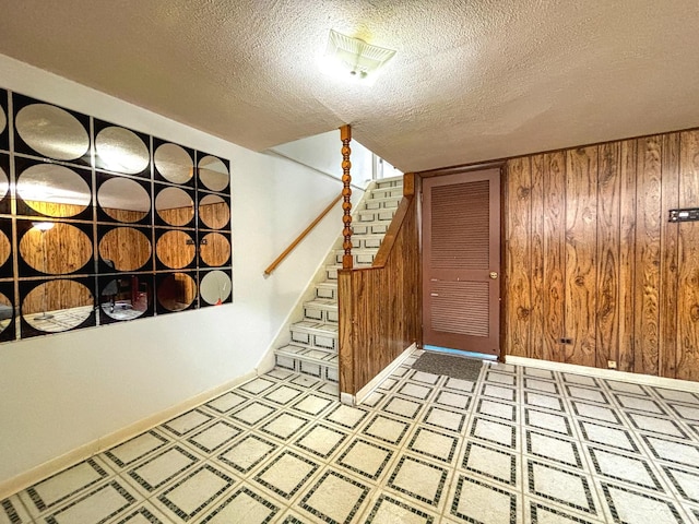 8664 Gregory Ln Unit E, Des Plaines, IL 60016 - foyer featuring a textured ceiling, wood walls, stairs, and light floors