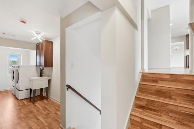 6709 W Menominee Pkwy, Palos Heights, IL 60463 - hallway with washing machine and clothes dryer, an upstairs landing, and light wood-style flooring