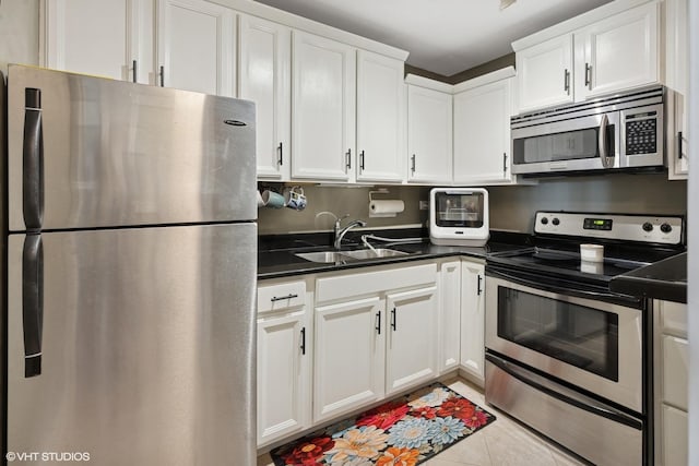 720 W Gordon Ter Unit 18R, Chicago, IL 60613 - kitchen featuring stainless steel appliances, white cabinets, dark countertops, and light tile patterned floors