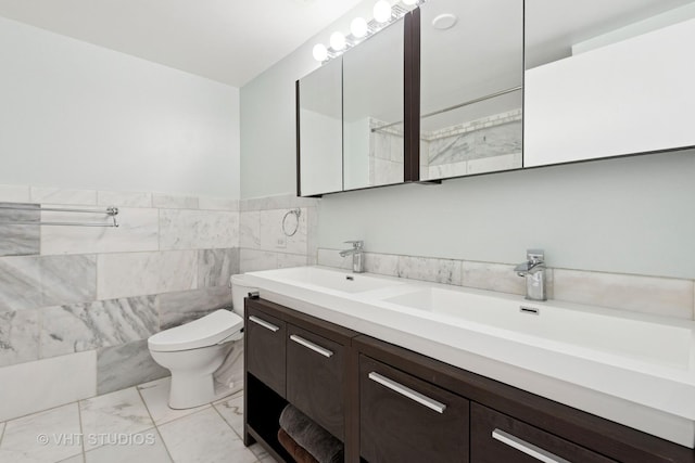 212 E Cullerton St Unit Ph06, Chicago, IL 60616 - bathroom featuring double vanity, marble look tile flooring, tile walls, and a wainscoted wall