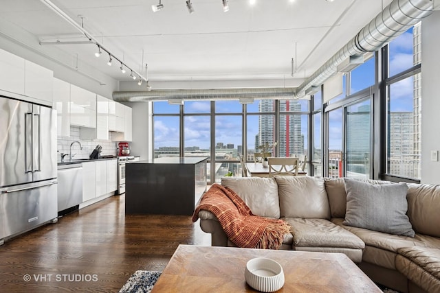 212 E Cullerton St Unit Ph06, Chicago, IL 60616 - living area featuring a view of skyline, dark wood-style floors, rail lighting, and expansive windows