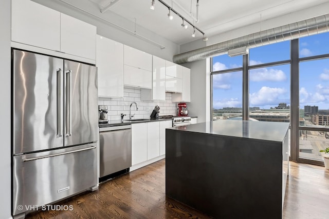 212 E Cullerton St Unit Ph06, Chicago, IL 60616 - kitchen with stainless steel appliances, dark countertops, tasteful backsplash, dark wood-style floors, and a city view