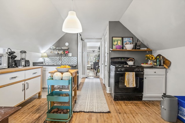 2119 N Karlov Ave, Chicago, IL 60639 - kitchen with black gas stove, white cabinetry, light wood finished floors, lofted ceiling, and hanging light fixtures
