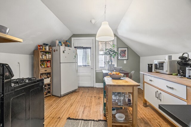 2119 N Karlov Ave, Chicago, IL 60639 - kitchen with white appliances, light wood finished floors, lofted ceiling, white cabinetry, and decorative light fixtures